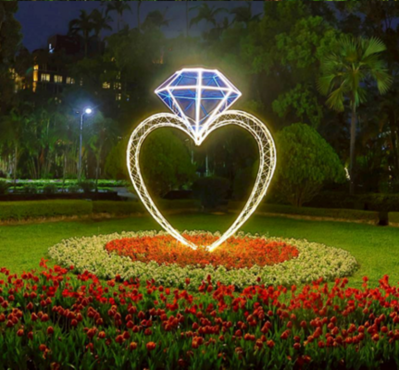 西式庭園的「浪漫相鬱」展區由公園處同仁手工打造出巨型愛心鑽戒，搭配燈條的設計，散發熠熠光輝十分迷人
