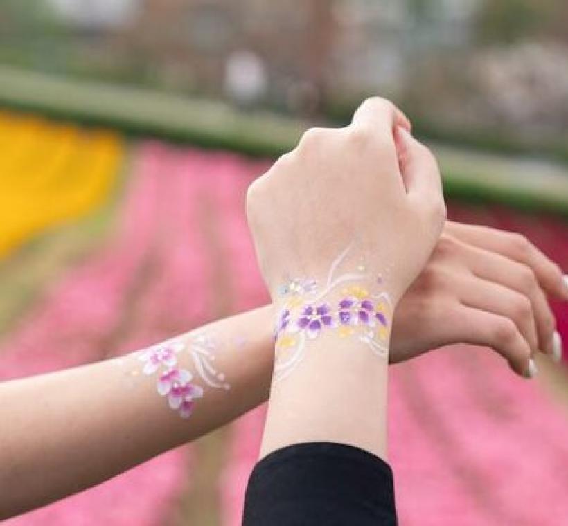 民眾帶著精美繪製的花朵與花海融為一體，在花海中愉快合影.